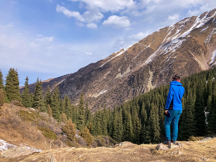 Mountain guide Jamil is standing on the edge looking at the trail below 