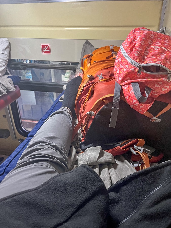 Finding my most comfortable position on the top bed inside a sleeper train